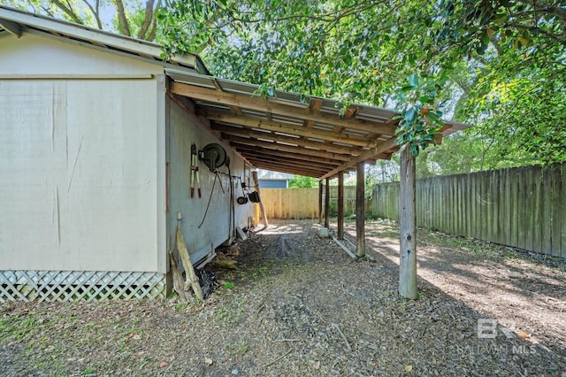 view of yard with driveway, a fenced backyard, and an attached carport