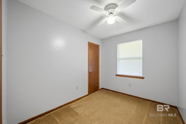 empty room with carpet, a textured ceiling, baseboards, and ceiling fan