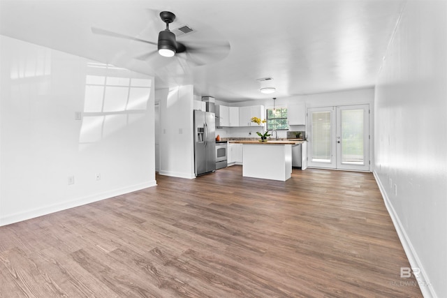 unfurnished living room with ceiling fan, french doors, sink, and wood-type flooring