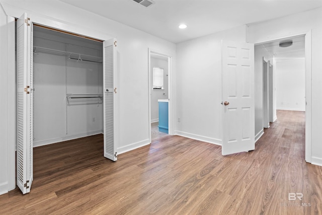 unfurnished bedroom featuring a closet and wood-type flooring