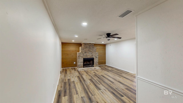 7770 Simmons Dr, Foley, AL 36535 - unfurnished living room with a ceiling fan, recessed lighting, wood walls, wood finished floors, and a fireplace