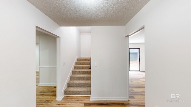 7770 Simmons Dr, Foley, AL 36535 - stairs with wood finished floors, a textured ceiling, and baseboards