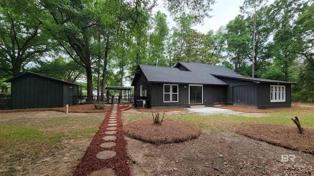 7770 Simmons Dr, Foley, AL 36535 - back of house with board and batten siding, central air condition unit, a shingled roof, and view of wooded area