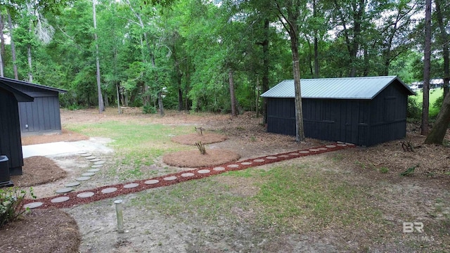 7770 Simmons Dr, Foley, AL 36535 - view of yard with an outbuilding, a wooded view, and a storage shed