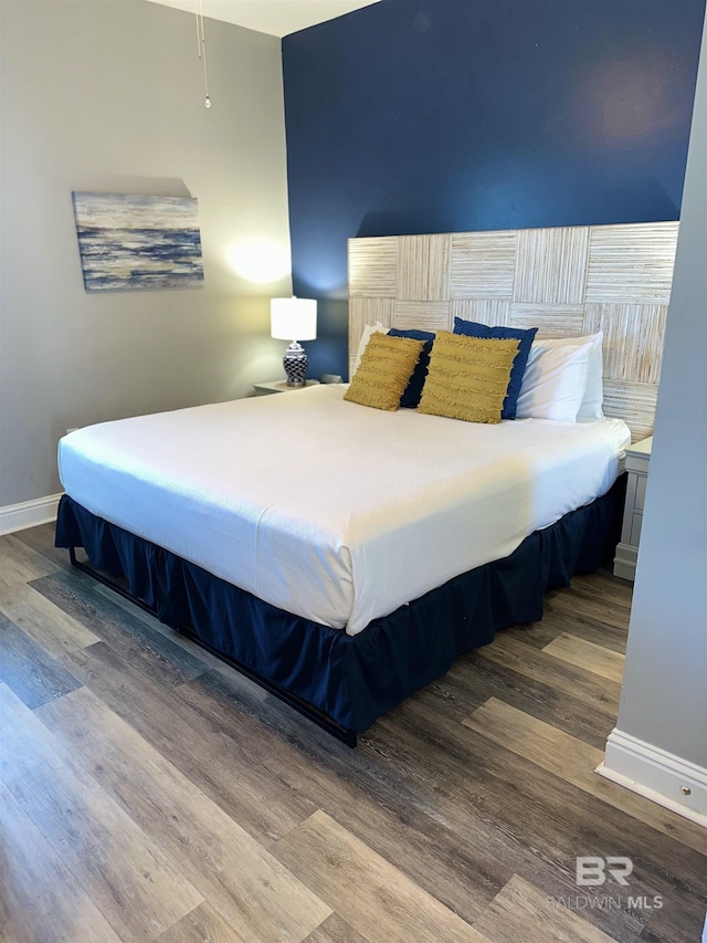 bedroom with wood finished floors and baseboards