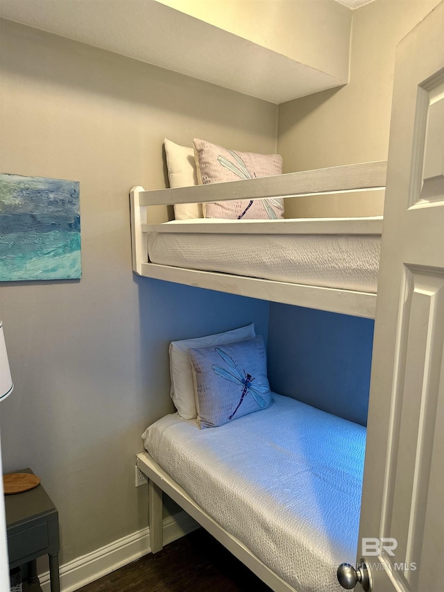 bedroom featuring baseboards and wood finished floors