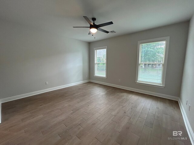 kitchen with white cabinetry, an island with sink, hardwood / wood-style floors, and pendant lighting