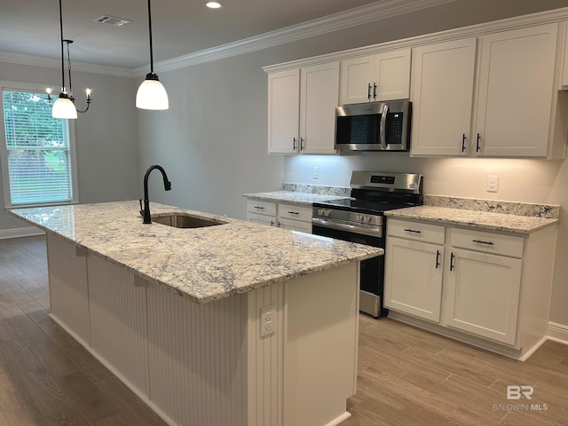 kitchen with a kitchen island with sink, stainless steel appliances, and white cabinets