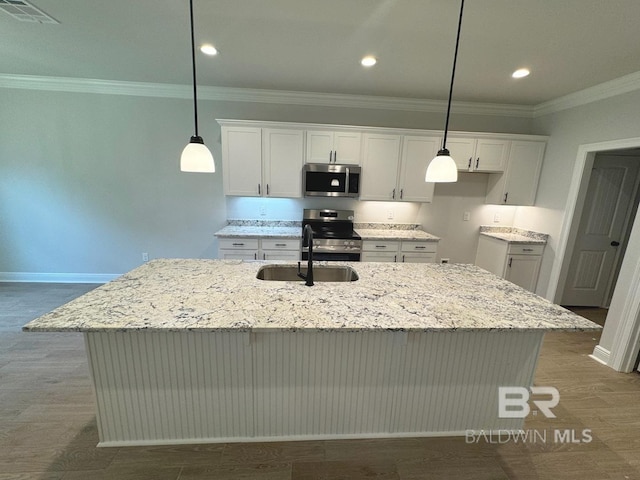 kitchen featuring stainless steel appliances, a kitchen island with sink, pendant lighting, and white cabinets