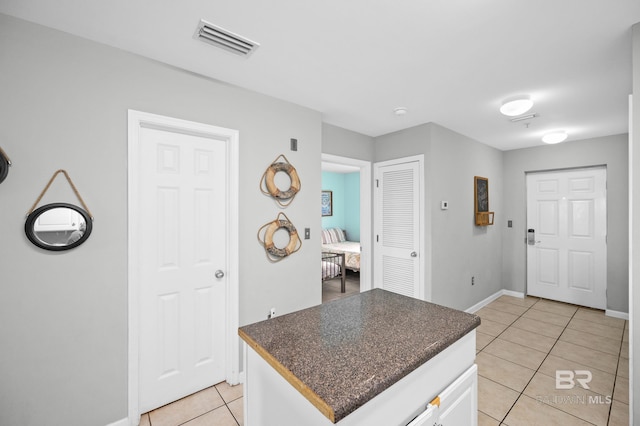 kitchen with light tile patterned floors and white cabinets