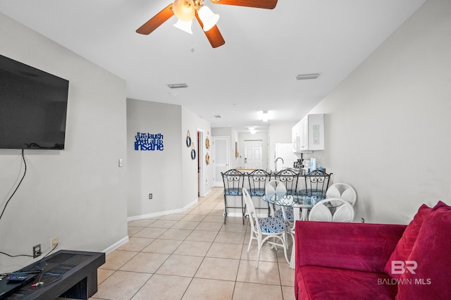 living room featuring light tile patterned flooring, sink, and ceiling fan