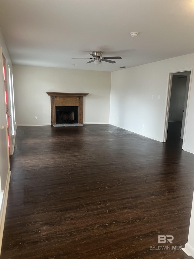 unfurnished living room featuring ceiling fan and dark hardwood / wood-style flooring