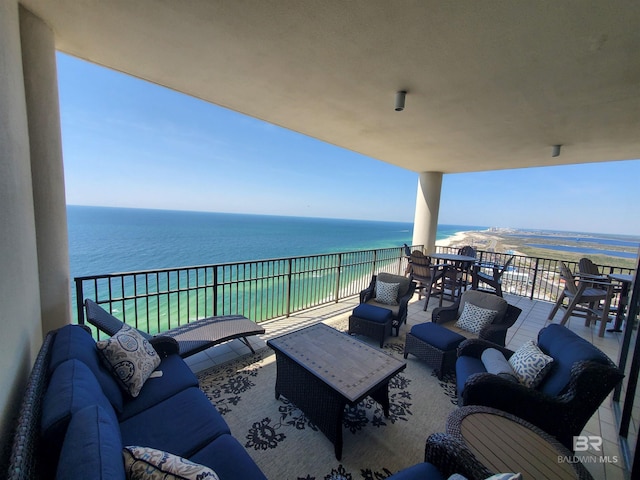 view of patio / terrace with a view of the beach, outdoor lounge area, a balcony, and a water view