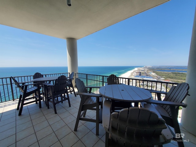 balcony with a water view and outdoor dining space