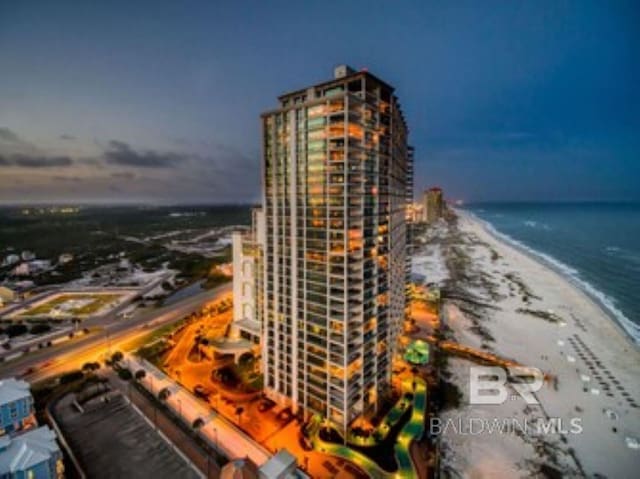 view of building exterior with a view of city, a view of the beach, and a water view