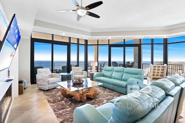 living area with light tile patterned floors, a ceiling fan, and ornamental molding