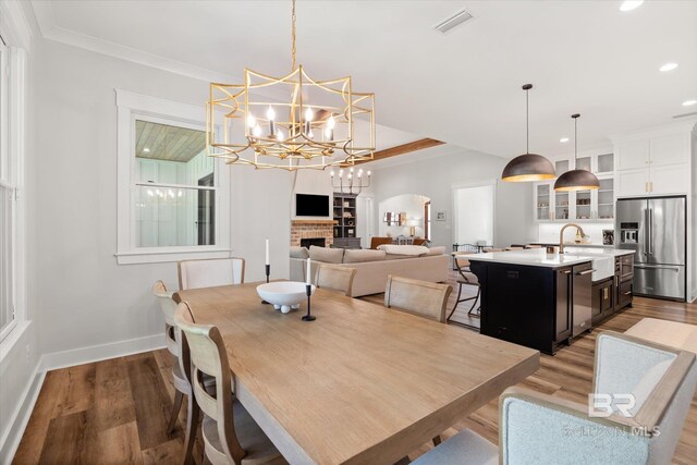 dining area with visible vents, light wood-style flooring, recessed lighting, a fireplace, and baseboards