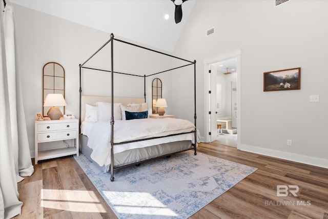 bedroom featuring visible vents, high vaulted ceiling, baseboards, and wood finished floors