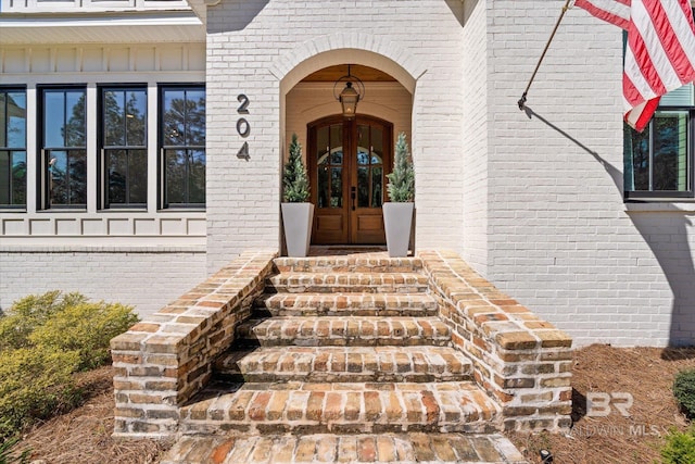 doorway to property with brick siding and french doors