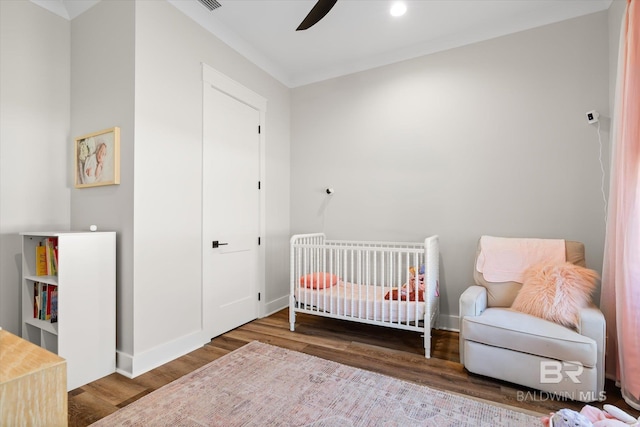 bedroom featuring ceiling fan, baseboards, and wood finished floors