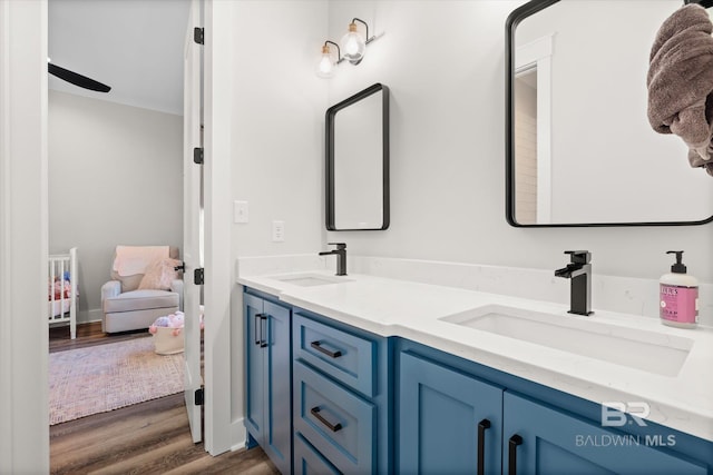 full bath featuring double vanity, wood finished floors, ensuite bathroom, and a sink