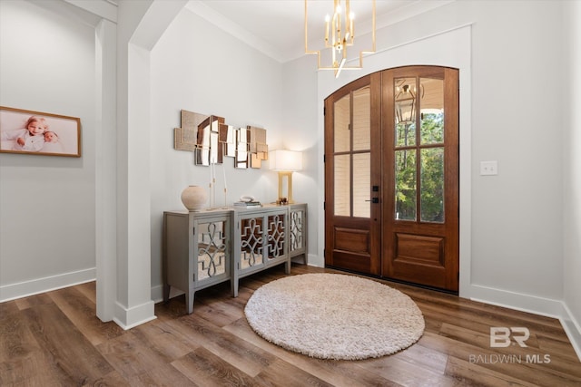 foyer with french doors, arched walkways, baseboards, and wood finished floors