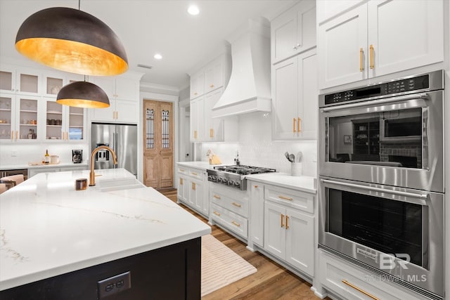 kitchen featuring white cabinetry, glass insert cabinets, premium range hood, and stainless steel appliances