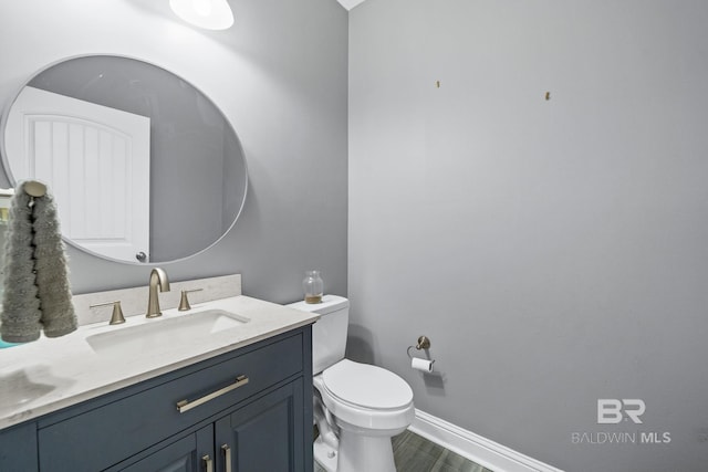 bathroom with vanity, wood-type flooring, and toilet