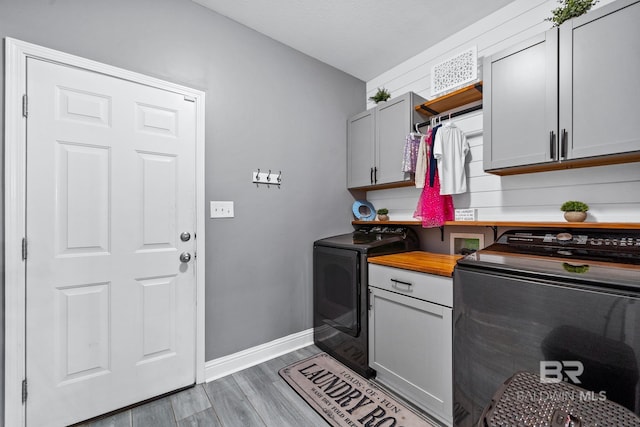 laundry area featuring cabinets, hardwood / wood-style floors, and independent washer and dryer