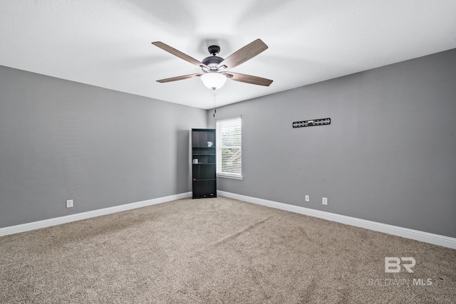 spare room featuring ceiling fan and carpet