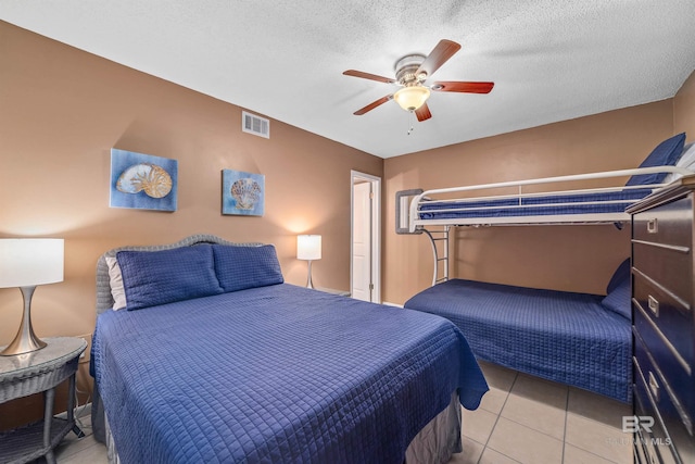 tiled bedroom featuring a textured ceiling and ceiling fan