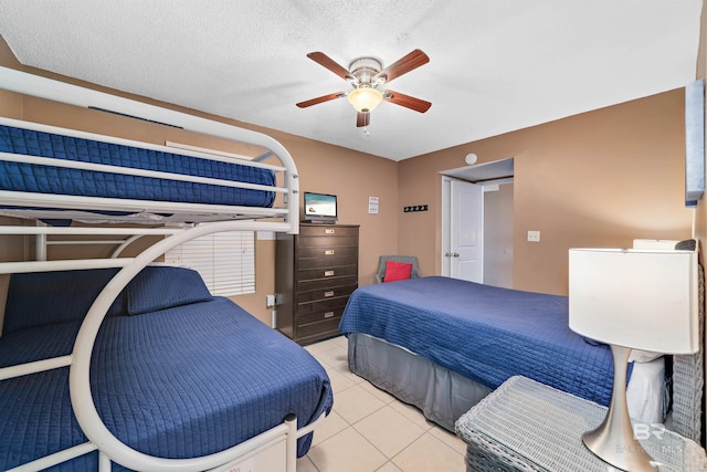 tiled bedroom featuring ceiling fan and a textured ceiling