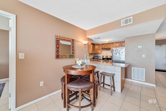 tiled dining space featuring a textured ceiling