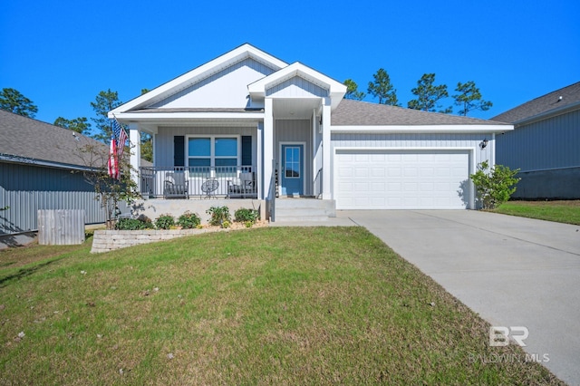 view of front of house with a front yard, a porch, and a garage