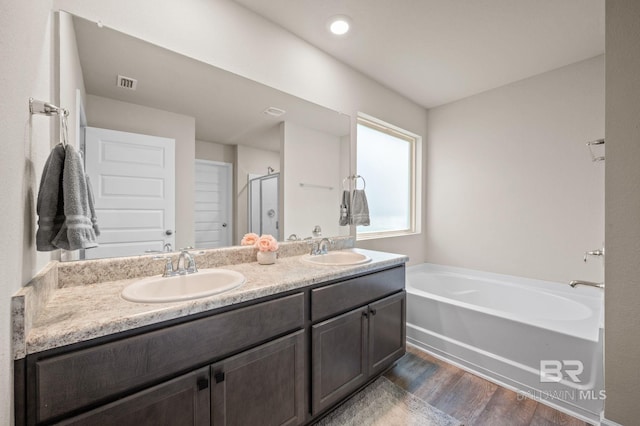 bathroom featuring separate shower and tub, hardwood / wood-style floors, and vanity