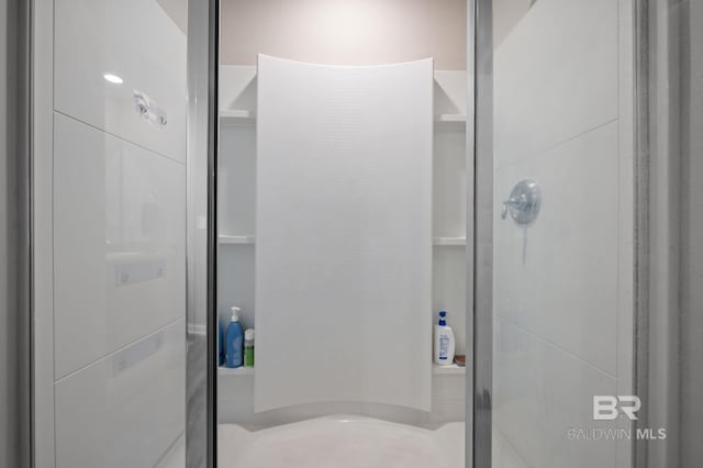 bathroom featuring a shower with door