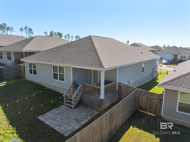 rear view of property with a yard and a patio