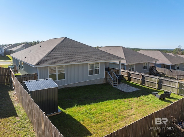 back of property with a storage unit and a lawn