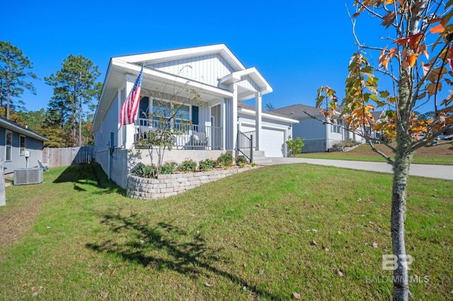 view of front of property featuring central AC, covered porch, a front yard, and a garage