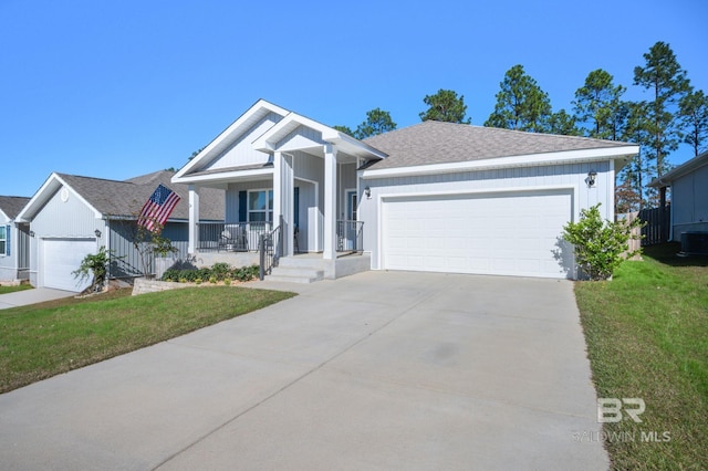 view of front of house featuring a front lawn, covered porch, and a garage