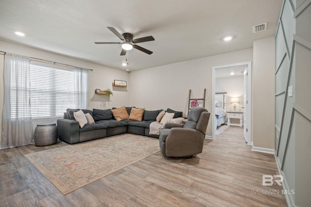 living room with ceiling fan and light wood-type flooring