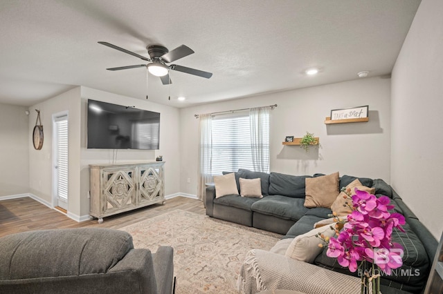 living room featuring hardwood / wood-style floors and ceiling fan