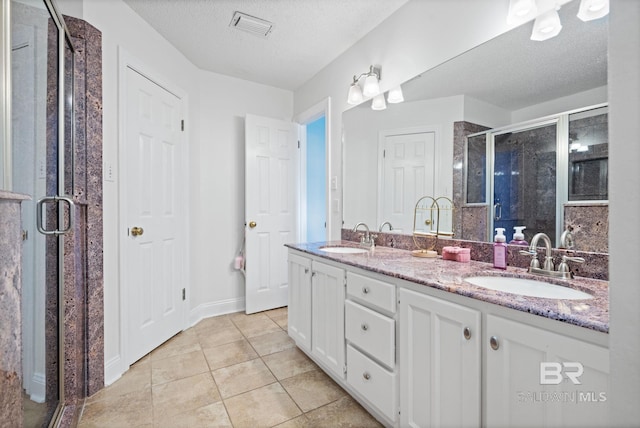 6417 Magnolia Place Ct, Mobile, AL 36695 - full bath featuring a shower stall, a textured ceiling, tile patterned flooring, double vanity, and baseboards