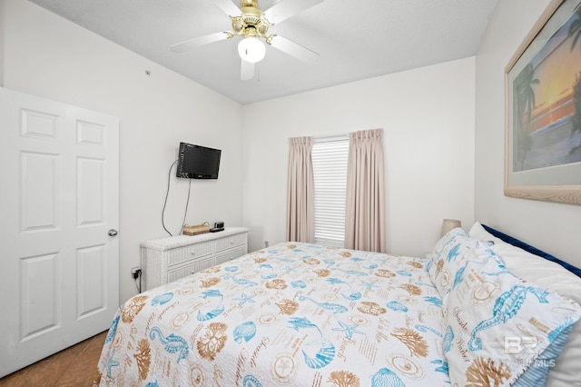 tiled bedroom featuring ceiling fan