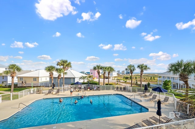 pool featuring a residential view, a patio, and fence