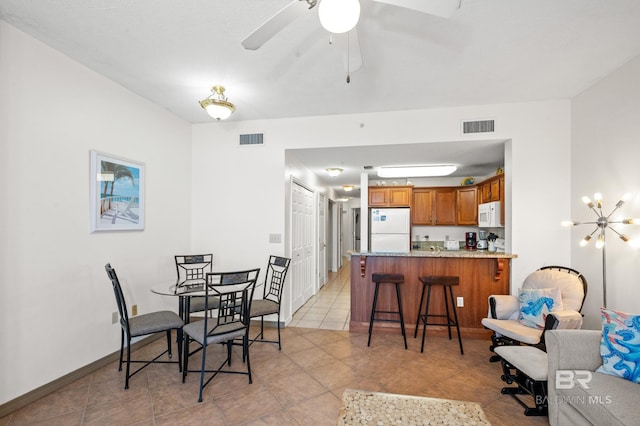 dining room with visible vents, ceiling fan, baseboards, and light tile patterned floors