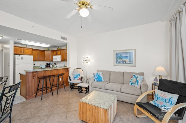 living area with visible vents, ceiling fan, and light tile patterned flooring