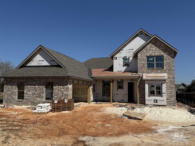 property in mid-construction featuring a garage and brick siding