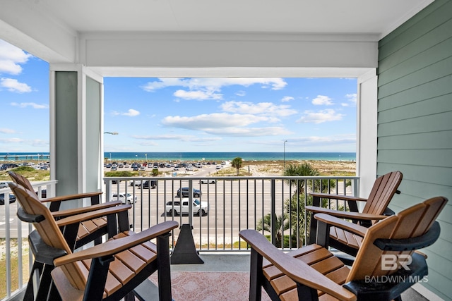 balcony with a water view and a beach view