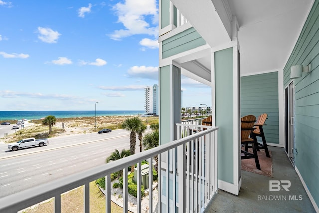 balcony featuring a water view and a view of the beach